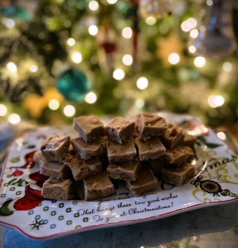 Penuche Fudge Candy on a holiday plate in front of a Christmas tree