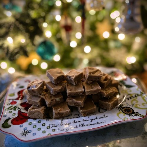 Penuche Fudge Candy on a holiday plate in front of a Christmas tree