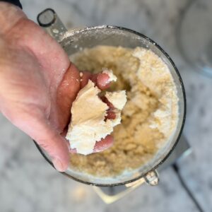 Overhead view of pie crust dough still in the food processor.