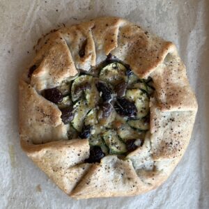 Over head shot of Gluten-Free Zucchini Galette fresh out of the oven, cooling on parchment paper